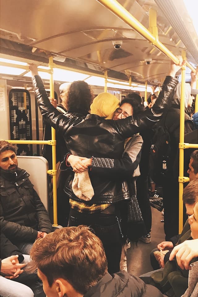 People hugging in a train