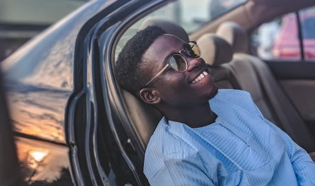 Black guy sitting in a car, smiling